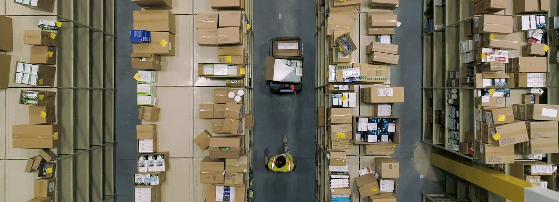 A materials handler walking the aisles of a warehouse with Chuck