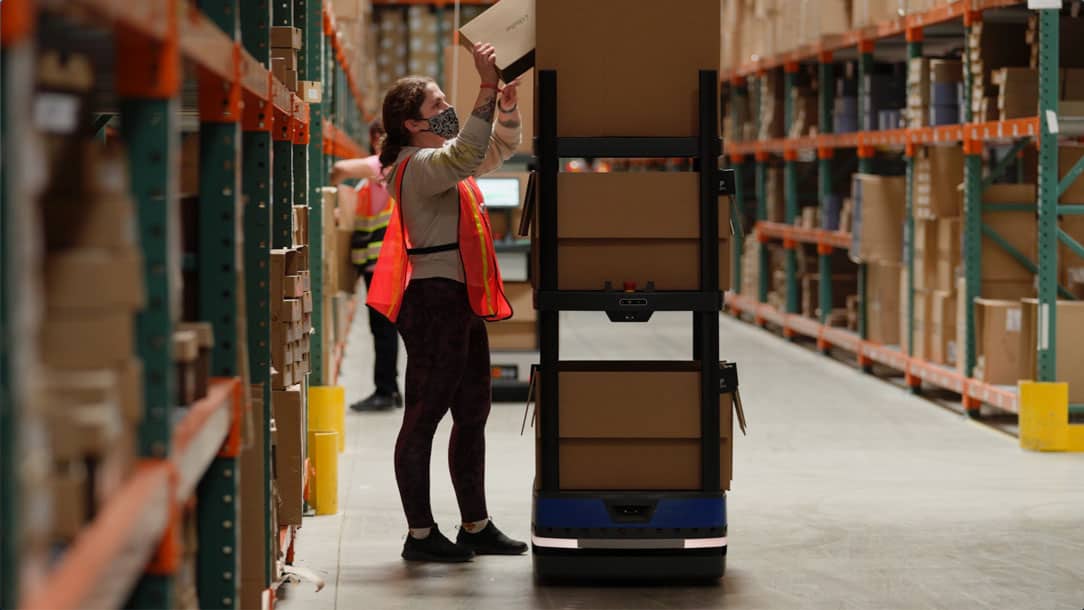 A warehouse associate picks an order with Chuck by 6 River Systems.